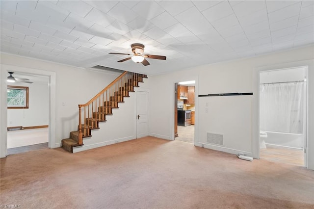 unfurnished living room featuring ornamental molding, ceiling fan, and light carpet