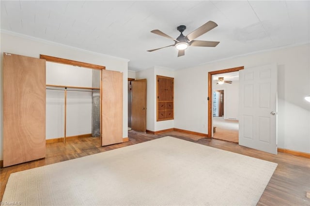 unfurnished bedroom with ornamental molding, ceiling fan, a closet, and hardwood / wood-style floors