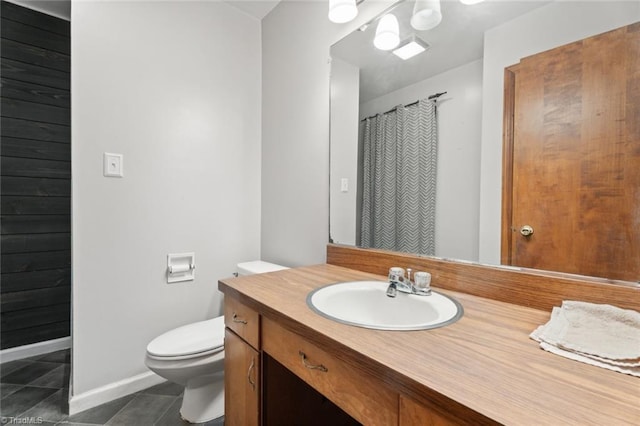 bathroom with tile patterned flooring, vanity, and toilet