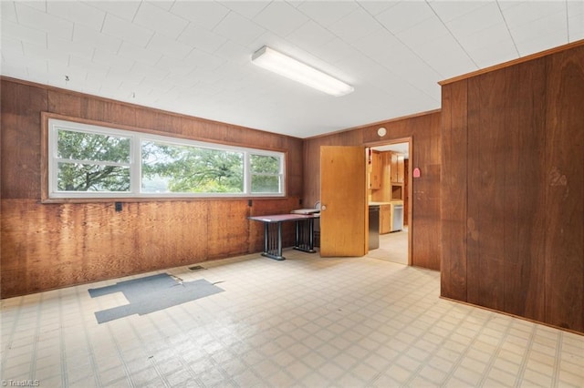 unfurnished room featuring wood walls