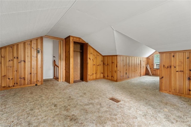 bonus room with cooling unit, wooden walls, lofted ceiling, and carpet