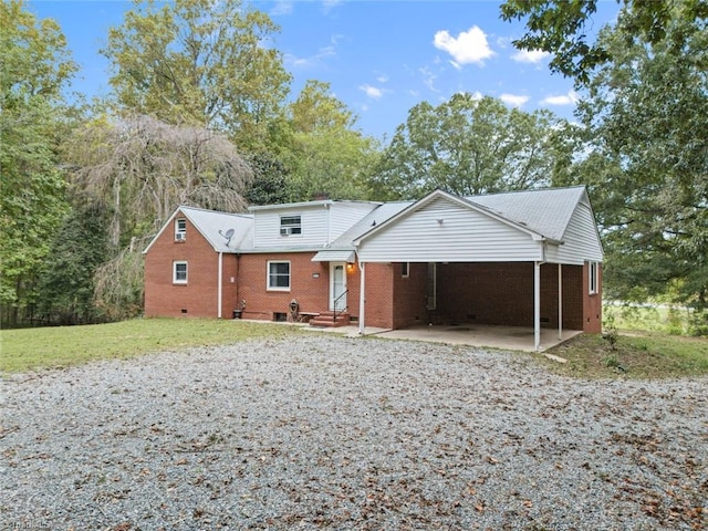 view of front of home with a carport and a front lawn