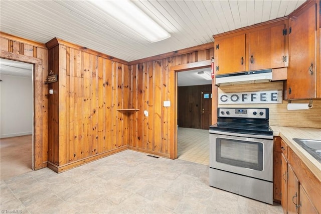 kitchen featuring wood walls and stainless steel range with electric cooktop