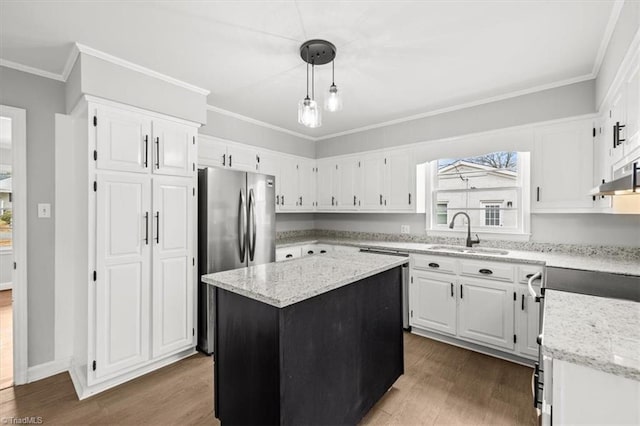 kitchen featuring sink, white cabinetry, decorative light fixtures, a center island, and stainless steel fridge