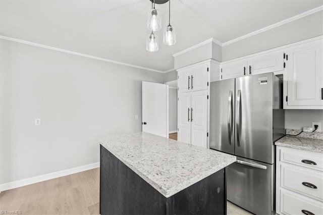 kitchen with crown molding, stainless steel refrigerator, white cabinetry, hanging light fixtures, and a kitchen island