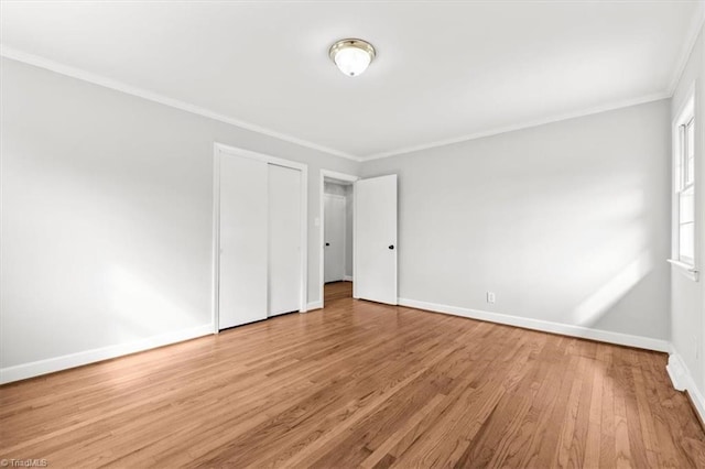 unfurnished bedroom with crown molding, light hardwood / wood-style flooring, and a closet