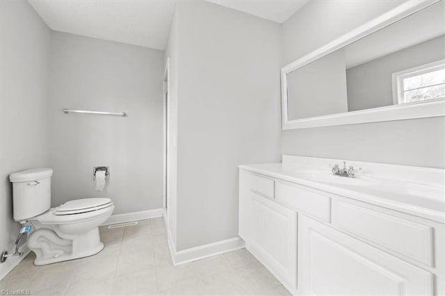 bathroom with tile patterned flooring, vanity, and toilet