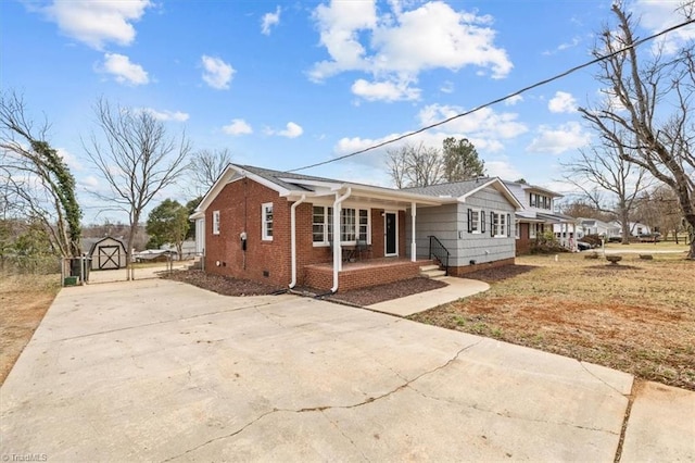 bungalow-style house featuring a porch and a shed