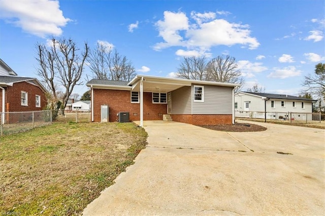 rear view of property with a carport, a yard, and central air condition unit