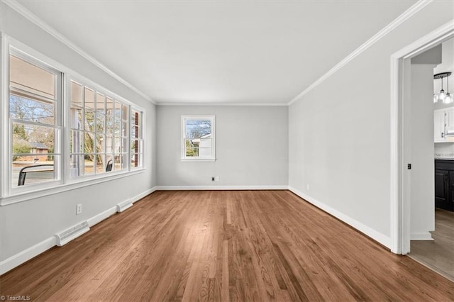 empty room featuring crown molding and wood-type flooring