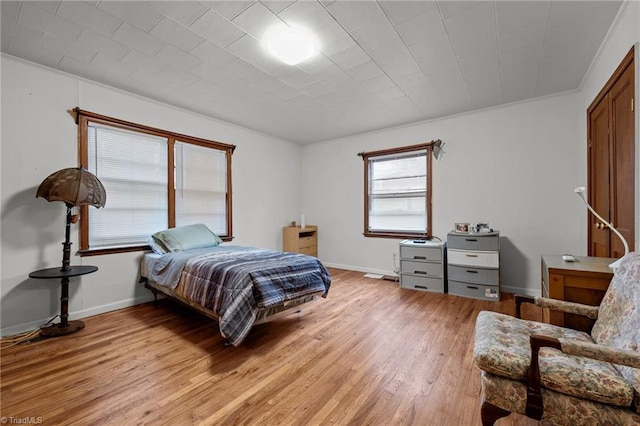 bedroom with light hardwood / wood-style floors and crown molding