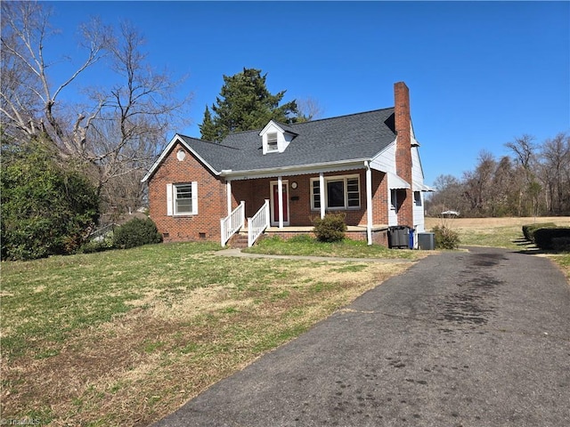 cape cod home with covered porch, a chimney, a front lawn, crawl space, and brick siding