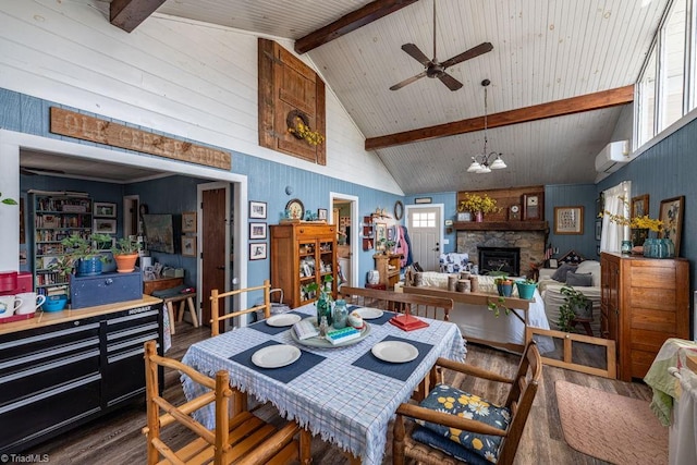 dining room with beamed ceiling, a healthy amount of sunlight, wood finished floors, and a wall unit AC