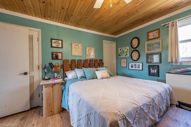 bedroom featuring wood ceiling, crown molding, a ceiling fan, and wood finished floors