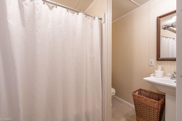 full bathroom featuring crown molding, toilet, tile patterned floors, and a sink