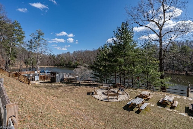 view of yard with a wooded view, fence, and a water view