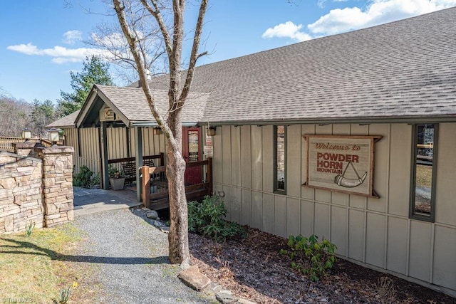 view of property exterior featuring board and batten siding and roof with shingles