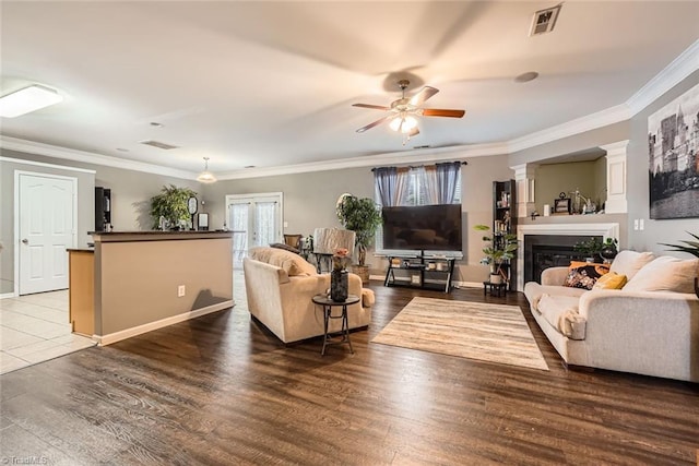 living room with ornamental molding, plenty of natural light, dark wood-type flooring, and ceiling fan