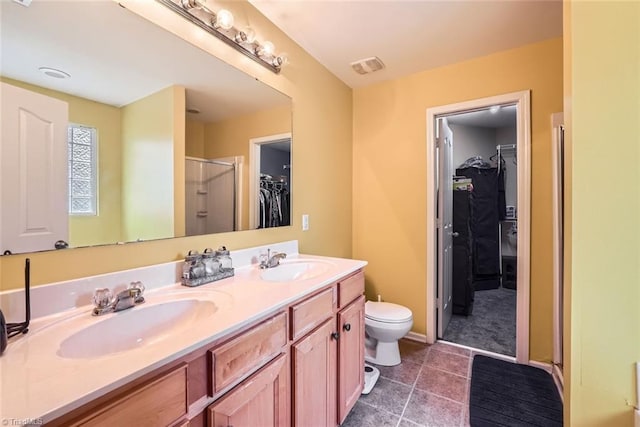 bathroom featuring vanity, a shower with shower door, tile patterned floors, and toilet