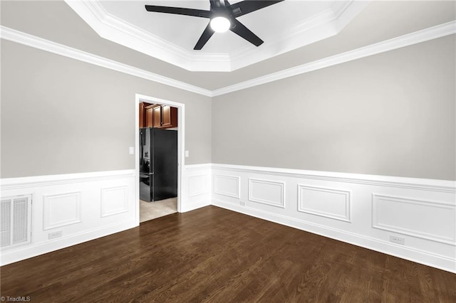 6107 Hanes Way, Clemmons, NC 27012 - spare room with a tray ceiling, a ceiling fan, dark wood finished floors, wainscoting, and crown molding