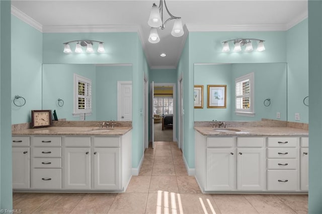 full bath with a sink, ornamental molding, and two vanities
