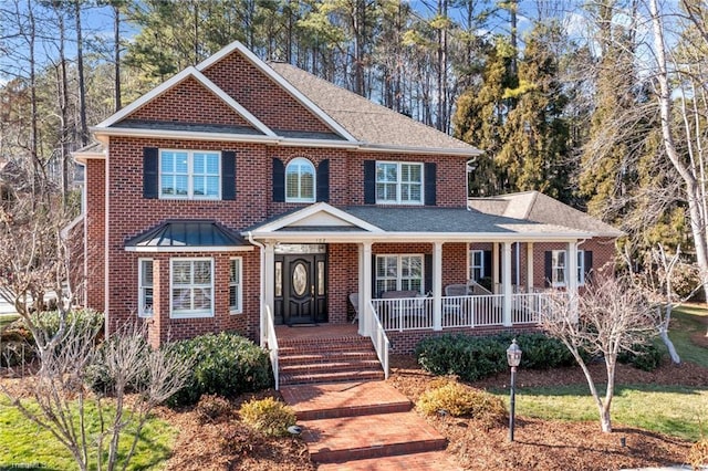 view of front of property featuring a porch, a shingled roof, and brick siding
