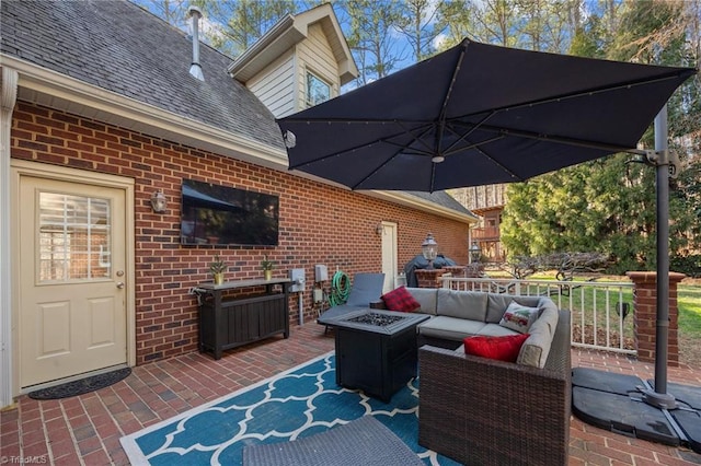 view of patio with an outdoor living space with a fire pit