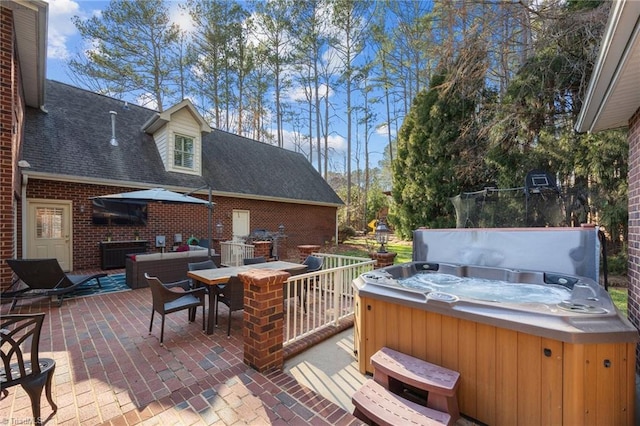 wooden deck with a hot tub, outdoor dining area, and a patio