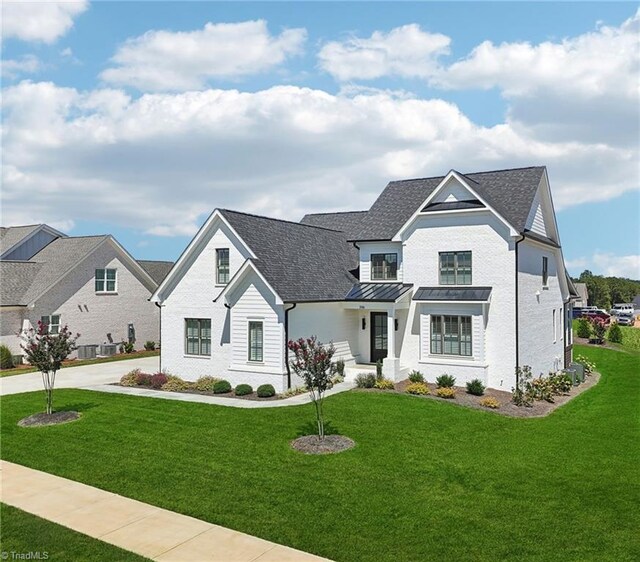 view of front of property featuring central AC and a front lawn