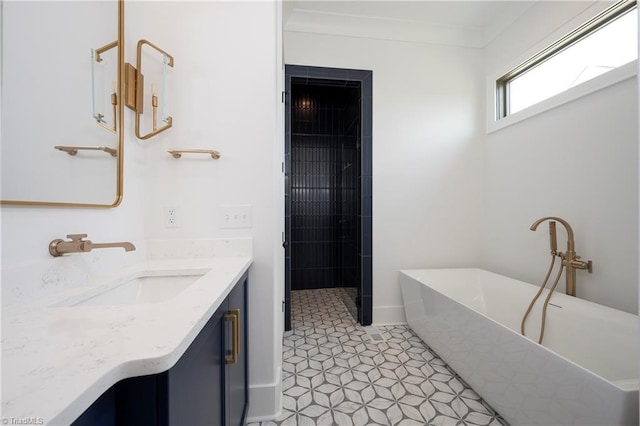 full bathroom with a freestanding tub, ornamental molding, a tile shower, and vanity