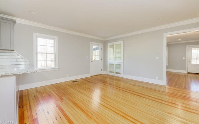 unfurnished living room with light hardwood / wood-style floors and crown molding