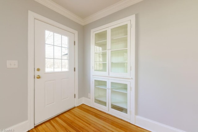 doorway to outside featuring wood-type flooring and crown molding