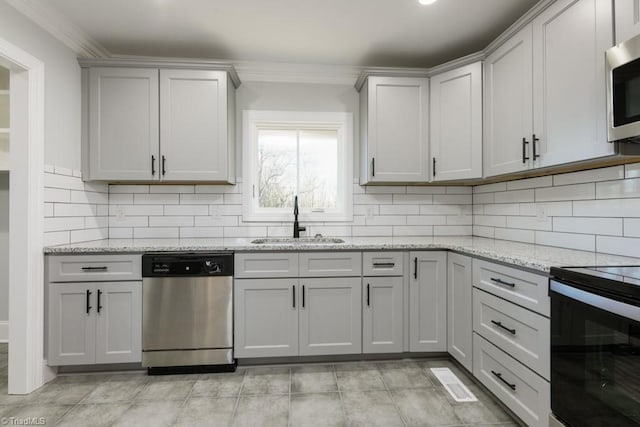 kitchen featuring light stone countertops, appliances with stainless steel finishes, backsplash, and sink