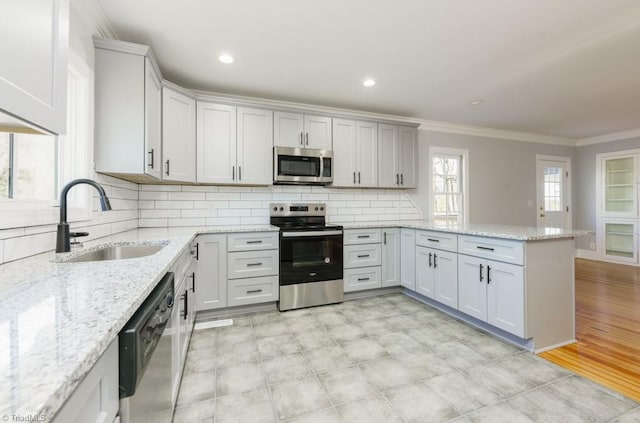 kitchen featuring kitchen peninsula, appliances with stainless steel finishes, white cabinetry, and sink