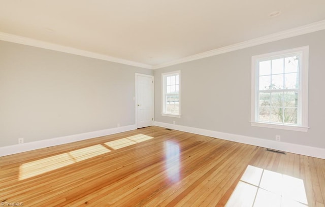 unfurnished room with hardwood / wood-style flooring, a healthy amount of sunlight, and ornamental molding