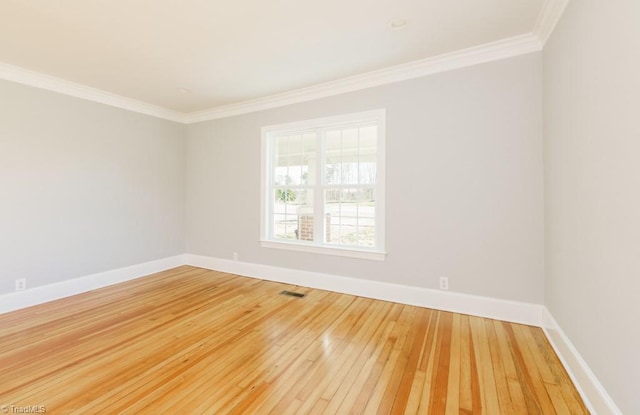 empty room with wood-type flooring and crown molding