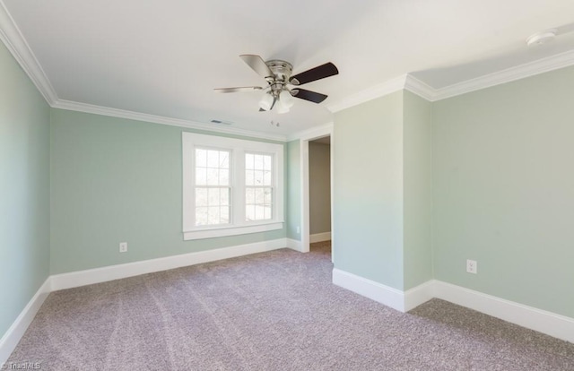 carpeted spare room with ceiling fan and crown molding