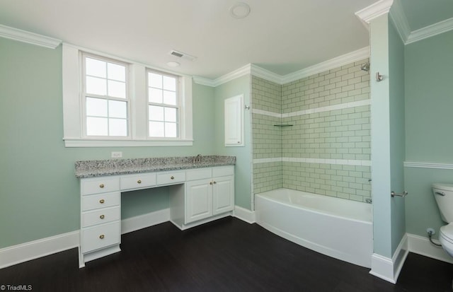 full bathroom with ornamental molding, vanity, tiled shower / bath combo, hardwood / wood-style flooring, and toilet