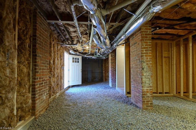 basement with carpet flooring and brick wall