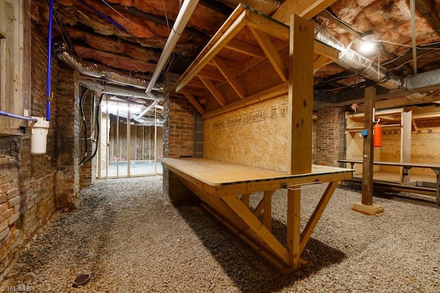 basement with carpet flooring and brick wall