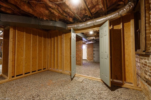 basement with carpet floors and brick wall