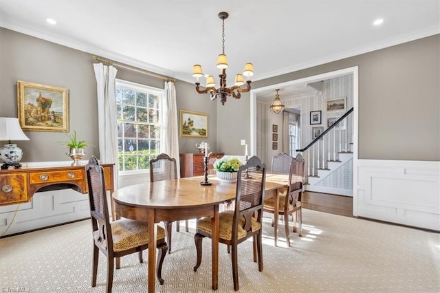 dining area featuring light wood-type flooring, crown molding, and an inviting chandelier