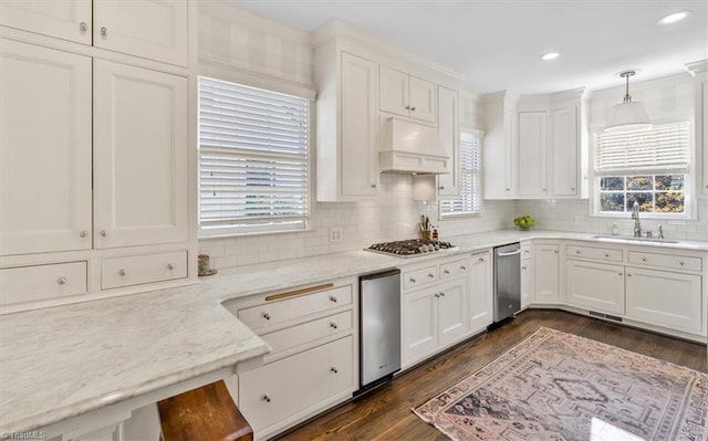 kitchen with white cabinetry, sink, dark wood-type flooring, premium range hood, and decorative light fixtures