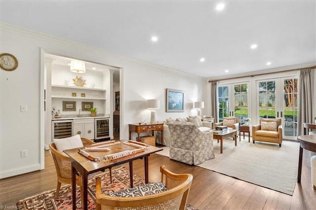 living room with hardwood / wood-style flooring, beverage cooler, and crown molding