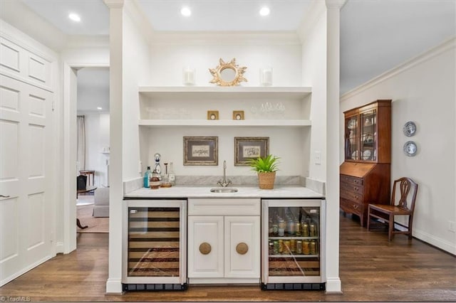 bar with beverage cooler, crown molding, and sink