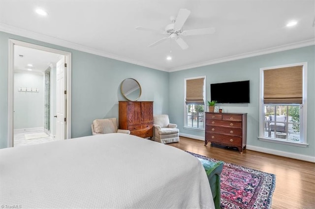 bedroom featuring ceiling fan, crown molding, ensuite bathroom, wood-type flooring, and multiple windows