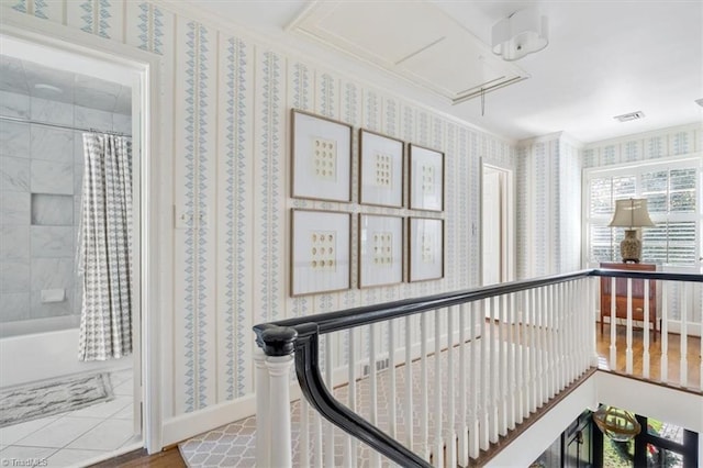 corridor with hardwood / wood-style floors and crown molding