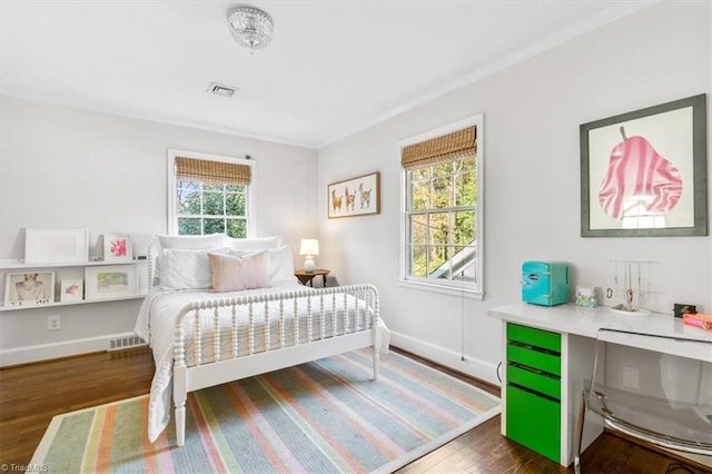 bedroom with crown molding and dark hardwood / wood-style floors