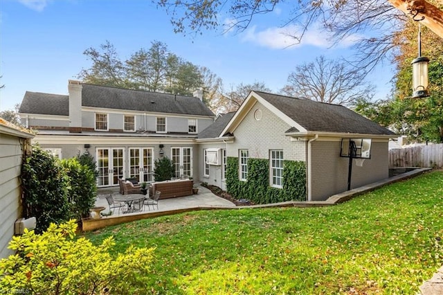 back of property featuring french doors, a patio area, and a lawn