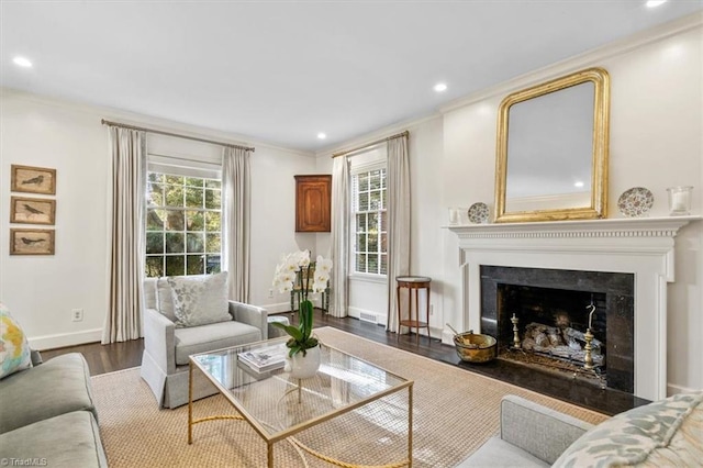 living room with a wealth of natural light, hardwood / wood-style floors, and crown molding